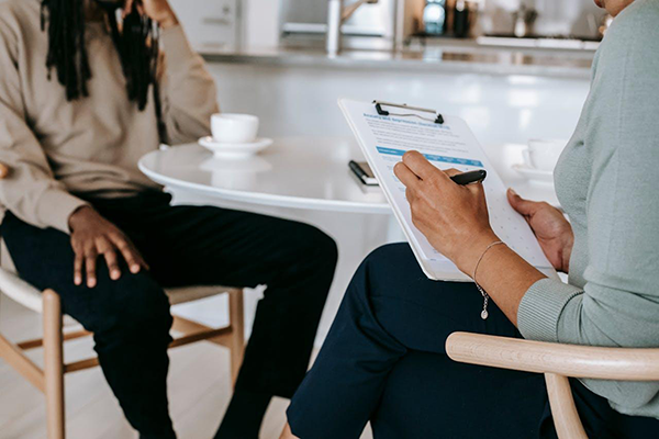 Image featuring an employer and a new employee sitting with the employee's resume.
